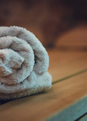 Traditional wooden sauna for relaxation with a set of clean towels. Good quality service in a classical steam sauna. First-class amenities of an eco-designed sauna. A towel put for using in sauna